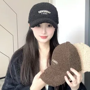 Detailed view of warm sherpa baseball cap with embroidered letters in three colors