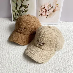 Winter lambswool baseball caps with 'Naivety' embroidery in camel and beige colors