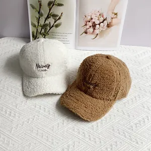 Detailed view of lamb wool baseball caps with Naivety 1768 embroidery in cream and brown