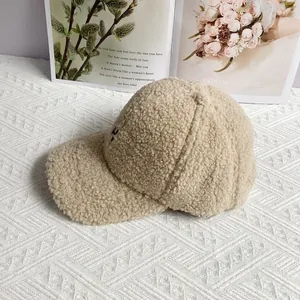 Close-up of beige faux shearling texture on a warm winter baseball cap for women