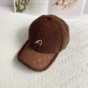 Detail einer braunen Teddy-Fleece-Baseballkappe mit besticktem A und Strass am Schirm