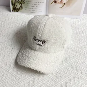 Close-up of white Sherpa fleece baseball cap with Naivety 1768 embroidery detail