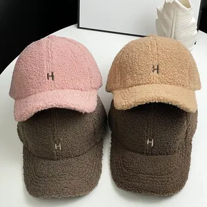 Detailed view of four colorful lamb wool baseball caps with H embroidery and soft texture