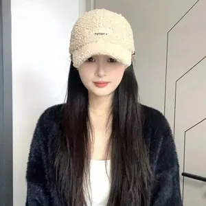 Detailed texture of beige lamb wool baseball cap with black embroidered lettering