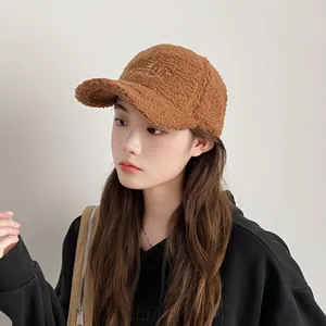 Detailaufnahme der braunen Teddy-Baseballkappe mit DREAM-Stickerei und warmer Plüsch-Textur