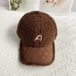 Detail der braunen Plüsch-Baseballkappe mit besticktem A und goldener Verzierung am Schirm