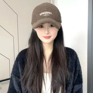 Close-up of brown sherpa baseball cap featuring embroidered Conserve text and soft texture