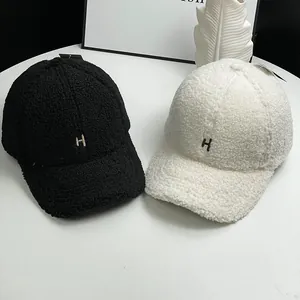 Close-up of embroidered H logo on soft lambswool baseball caps in black and white
