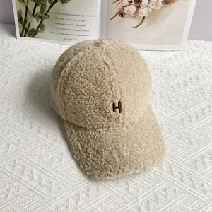 Close-up of beige lamb wool baseball cap featuring premium embroidered letter H detail