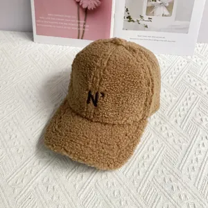 Detailed macro view of the brown fuzzy lamb wool fabric and embroidered N letter on the cap
