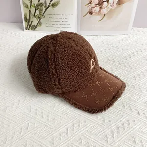 Detail der Teddy-Fleece-Basecap mit goldenem Metall-A und Sternenmuster am Schirm