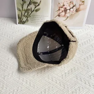 Close-up of warm beige lambswool baseball cap with soft texture and letter embroidery
