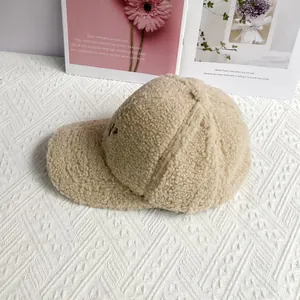 Detailed close-up of embroidered NY logo on soft beige fleece baseball cap surface