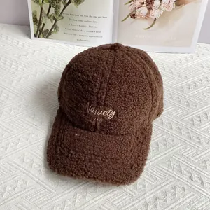 Detail of embroidered letters on deep brown lambswool baseball cap for winter season