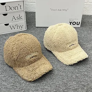 Detail of soft lamb wool baseball caps in khaki and cream with letter embroidery