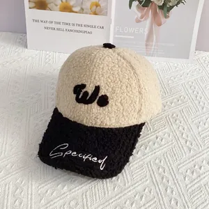 Detalle de la gorra de béisbol de borreguito beige y negro con bordado 'W' rizado
