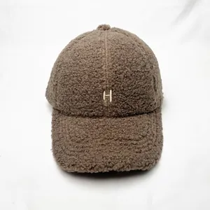 Close-up of embroidered H letter on dark brown sherpa fleece warm baseball cap