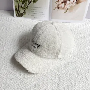 Detailed embroidery on a soft beige fleece baseball cap with warm winter texture