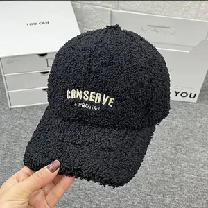 Close-up of black fleece baseball cap featuring white embroidered CONSERVE & PROTECT text