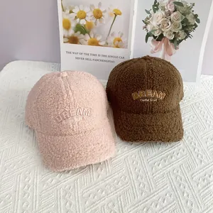 Details von rosa und braunen Lammwoll-Baseballkappen mit Dream-Stickerei-Textur