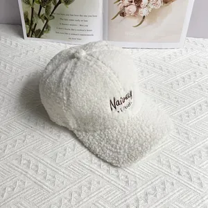 Detailed close-up of white fleece baseball cap with brown Naivey 1768 embroidery