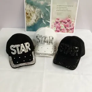 Detail of faux mink fur baseball caps with rhinestone STAR logo and crystal brim