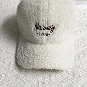 Close-up of white fleece baseball cap featuring black Naivety 1768 embroidery detail