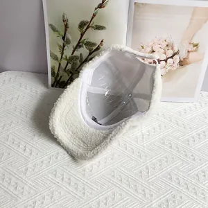Detail of white sherpa baseball cap with soft texture and internal support frame