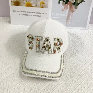 Close-up of STAR letter logo made of pearls and rhinestones on white knit baseball cap