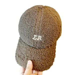 Detailansicht der braunen Lammwoll-Basecap mit weißer LR-Stickerei und weichem Fleece