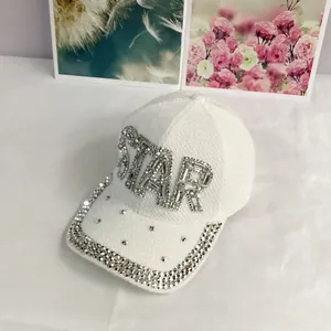 Close-up of sparkling rhinestone STAR lettering and crystals on a white knit baseball cap
