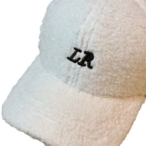 Detailaufnahme der weißen Plüsch-Basecap mit schwarzer LR-Stickerei aus Fleece-Material