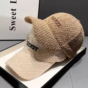 Close-up of TRENDY embroidery on teddy fleece baseball caps in brown and beige
