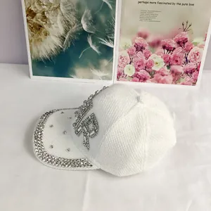 Close-up of luxury white knit baseball cap with sparkling rhinestone star and letter pattern