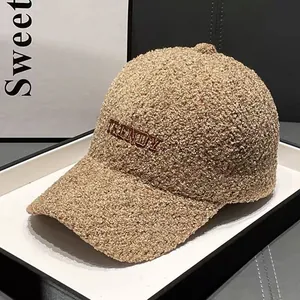 Detailed close-up of TRENDY embroidery on soft teddy fleece baseball cap in light brown