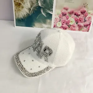 Close-up of sparkling rhinestone STAR lettering and crystal trim on white knit baseball cap