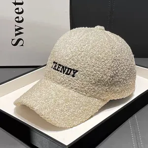 Close-up of TRENDY embroidery on off-white teddy fleece baseball cap texture
