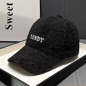 Detail of black teddy fleece baseball cap with white TRENDY embroidery and plush texture
