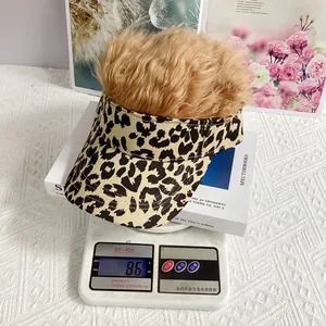 Gorra con peluca de leopardo en báscula mostrando un peso ligero de 86g