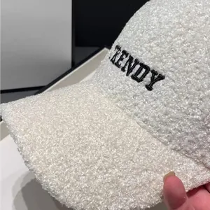 Close-up of white teddy fleece baseball cap with black TRENDY embroidery detail