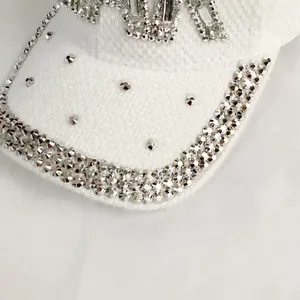 Macro detail of white tweed baseball cap featuring hand-set crystals and metal star studs
