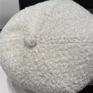 Close-up of the plush teddy fleece texture and top button on a white baseball cap