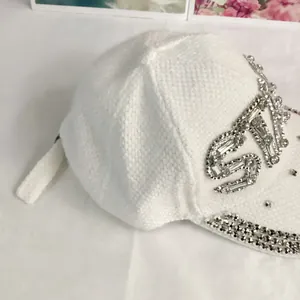 Detail of white knit baseball cap with sparkling crystal STAR embroidery and rhinestone brim