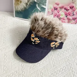 Detail of dark blue denim baseball cap with brown wig and leopard heart embroidery