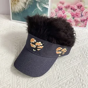 Detail of creative denim visor hat with black curly hair wig and camouflage heart patches