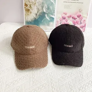 Detailansicht dicker Teddy-Fleece-Caps mit missed-Stickerei in Braun und Schwarz