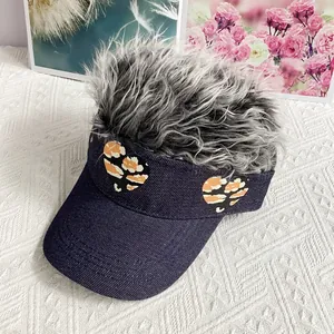 Detail of blue denim baseball cap with grey wig hair and leopard heart patches