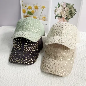 Detail of velvet baseball caps with metallic rivets in green, black, cream and khaki colors