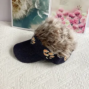 Close-up of denim visor wig hat with leopard heart patterns on quilted background
