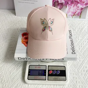 Pink cotton baseball cap with rhinestone butterfly detail showing lightweight 68g weight